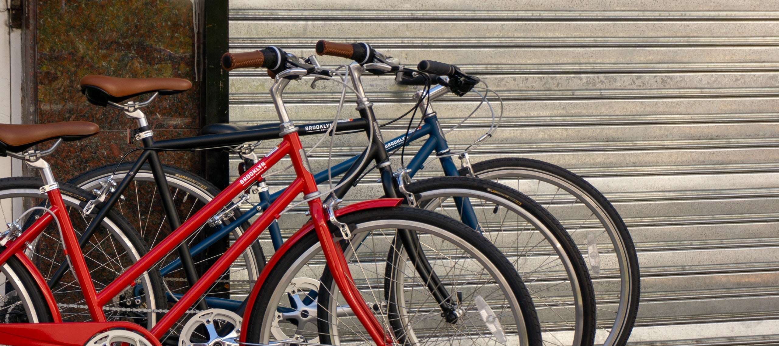 3 bicycles in a row, one Cardinal Red Franklin, one Matte Black Bedford, one Matte Denim Lorimer