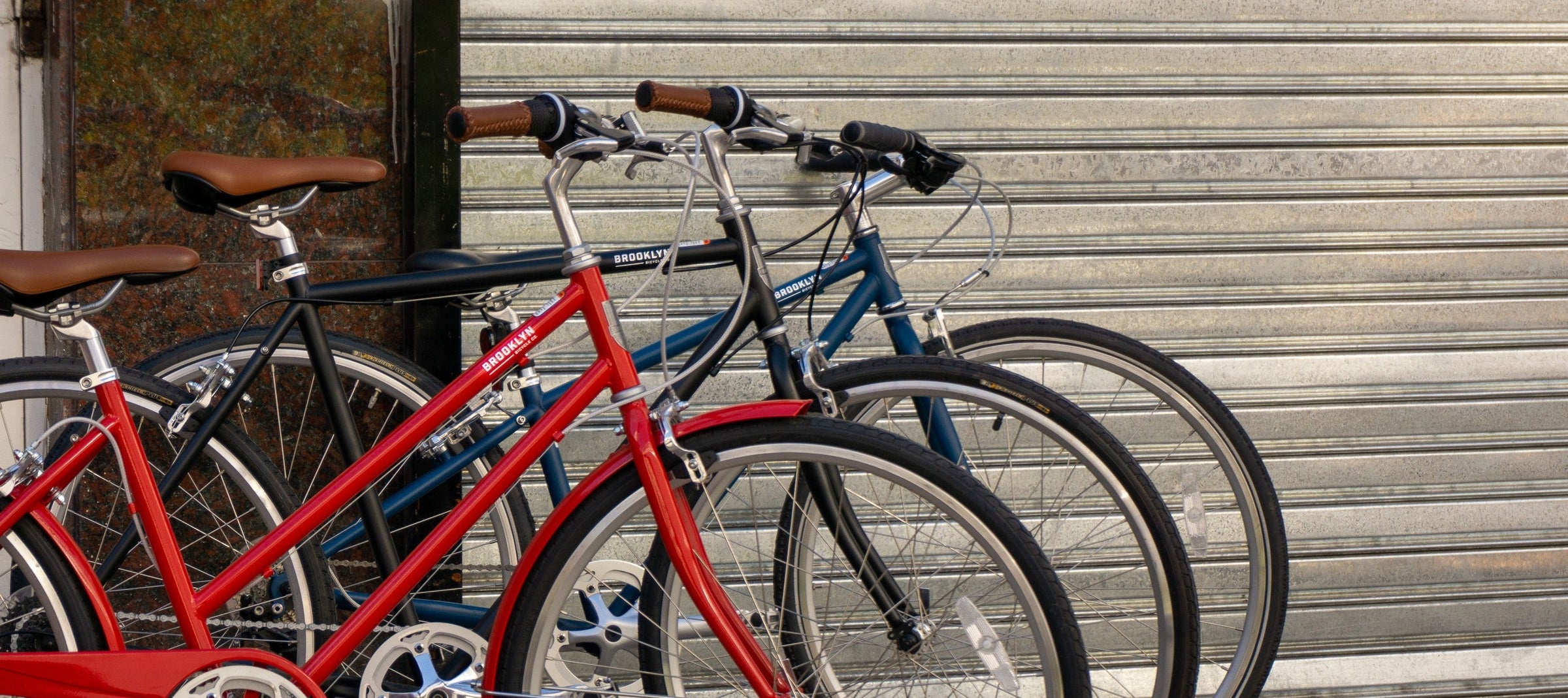 3 bicycles in a row, one Cardinal Red Franklin, one Matte Black Bedford, one Matte Denim Lorimer