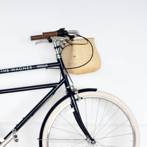 Driggs bike with "The Wagner" decal and rattan basket hanging from handlebar