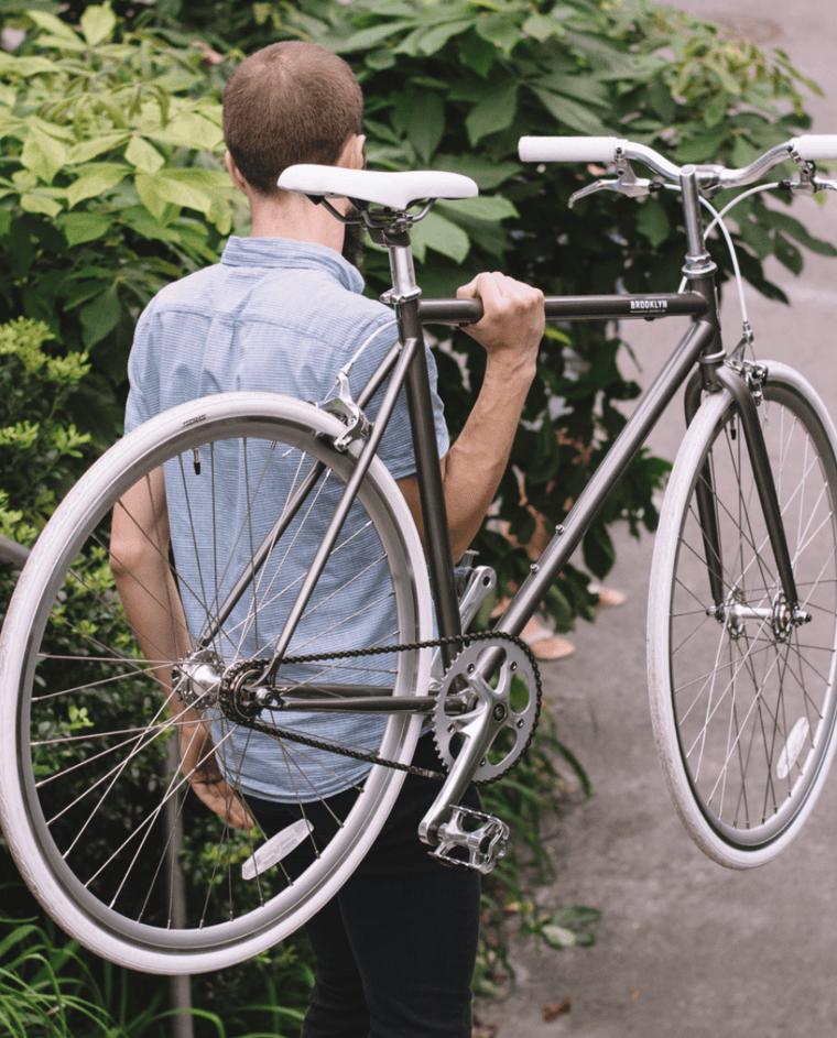 A rider carrying a Wythe single speed bike over his shoulder